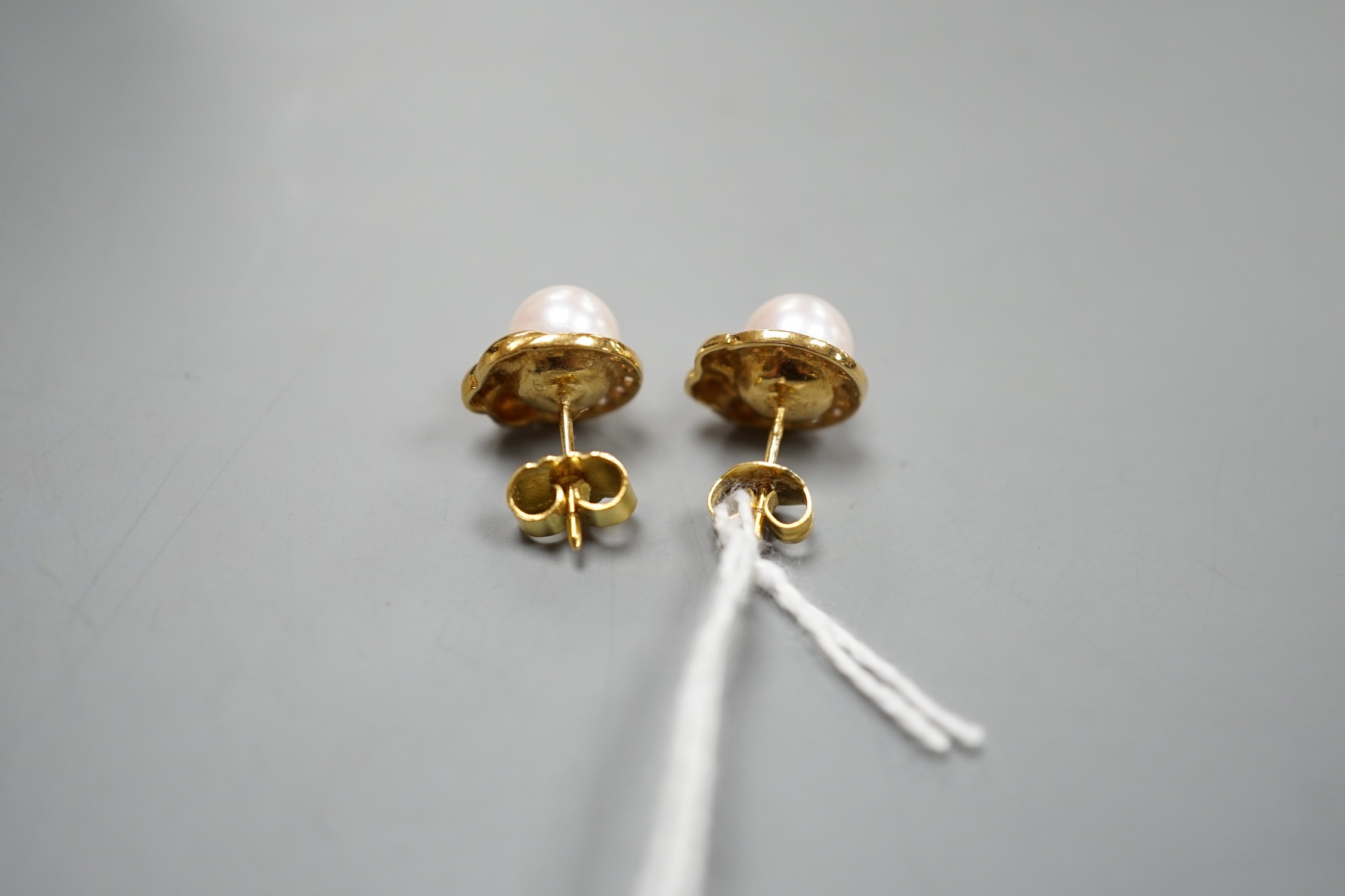 A modern pair of 18ct gold, cultured pearl and diamond chip set earrings, 12mm, gross weight 4.7 grams.